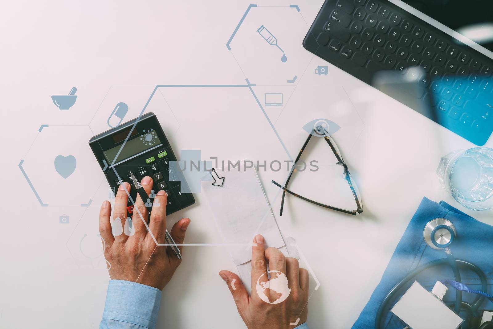 top view of Healthcare costs and fees concept.Hand of smart doctor used a calculator for medical costs in modern hospital with VR icon diagram