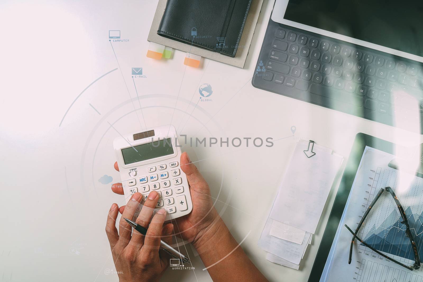 top view of businessman hand working with finances about cost and calculator and latop with mobile phone on withe desk in modern office with VR icon diagram