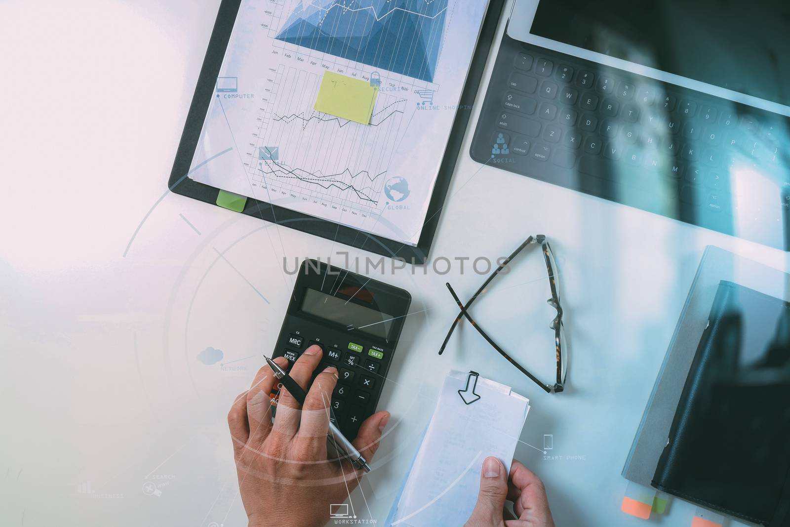 top view of businessman hand working with finances about cost and calculator and latop with mobile phone on withe desk in modern office with VR icon diagram