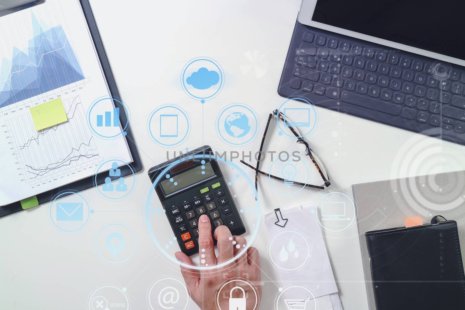 top view of businessman hand working with finances about cost and calculator and latop with mobile phone on withe desk in modern office with VR icon diagram