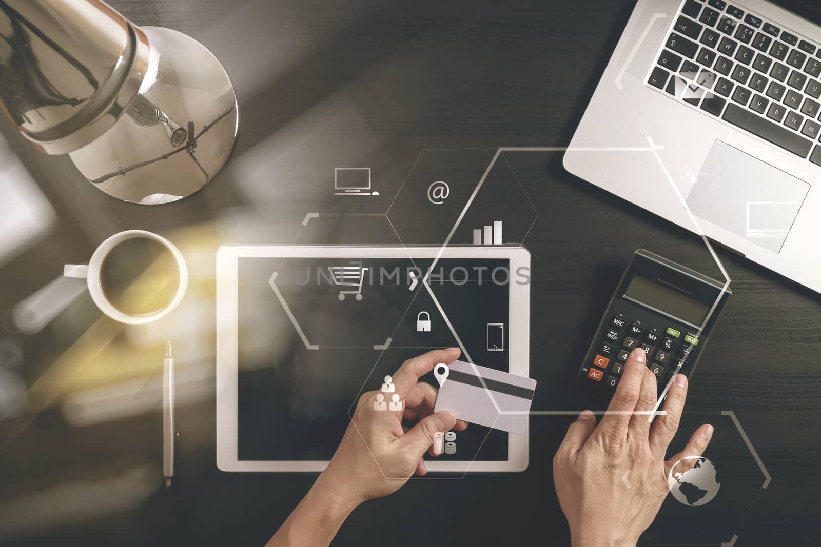 Internet shopping concept.Top view of hands working with laptop and credit card and tablet computer on dark wooden table background with Vr diagram