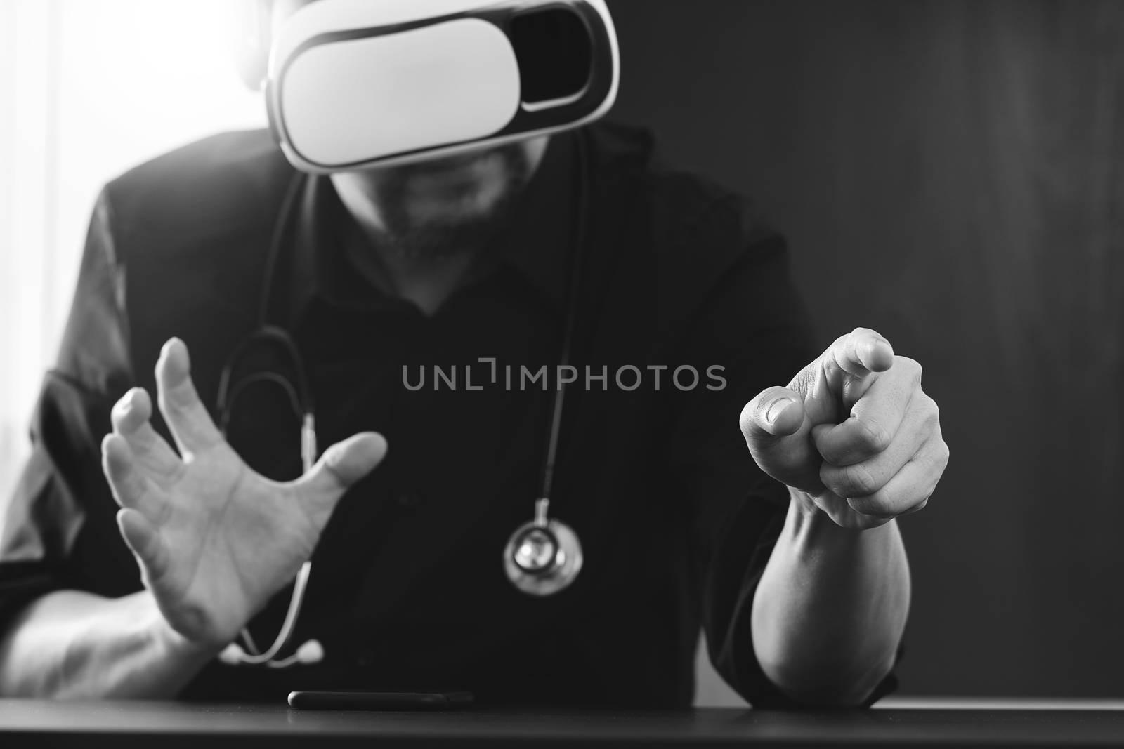 businessman wearing virtual reality goggles in modern office with mobile phone using with VR headset,black and white