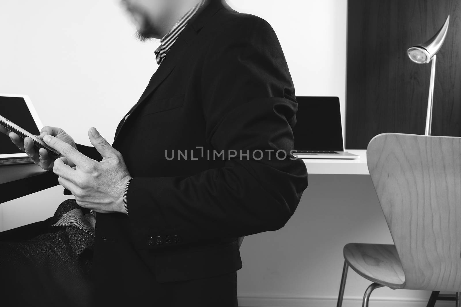 businessman working with smart phone and digital tablet and laptop computer in modern office,balck and white 