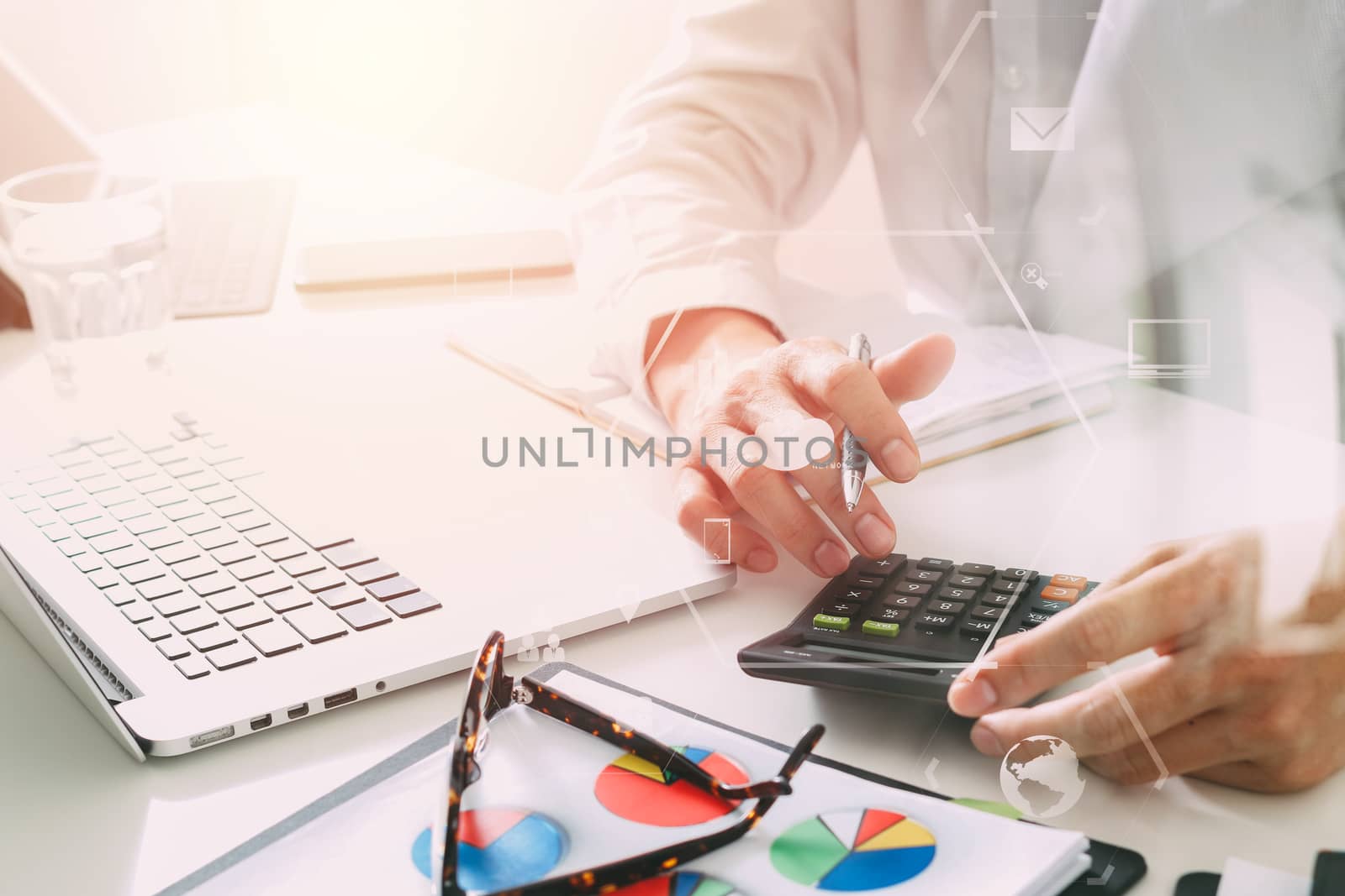 businessman hand working with finances about cost and calculator and latop with mobile phone on withe desk in modern office with VR icon diagram