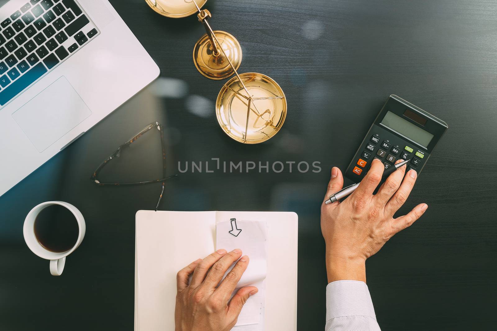 justice and law concept.businessman or lawyer or accountant working on accounts using a calculator and laptop computer and documents in modern office