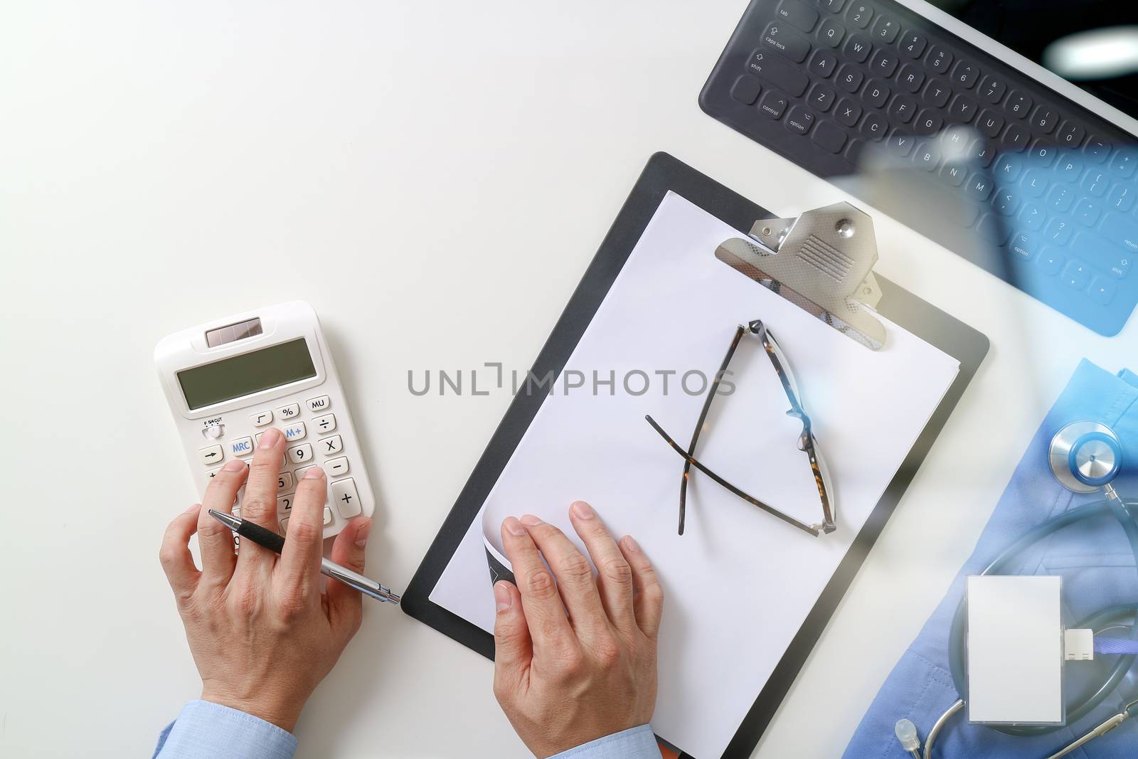 top view of Healthcare costs and fees concept.Hand of smart doctor used a calculator for medical costs in modern hospital 