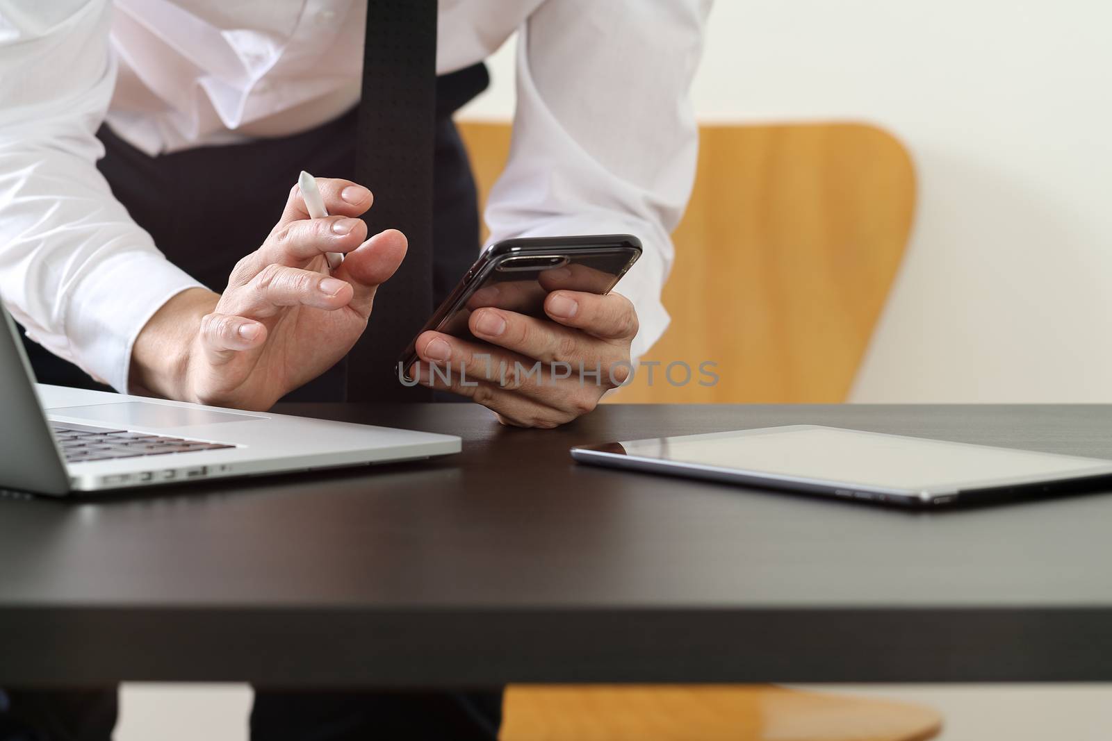 close up of businessman working with smart phone and digital tab by everythingpossible