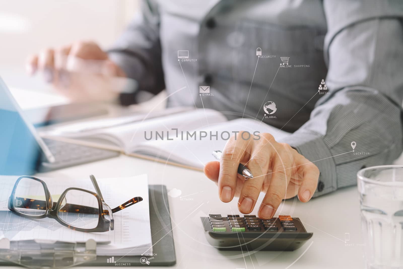 businessman hand working with finances about cost and calculator and latop with mobile phone on withe desk in modern office with VR icon diagram