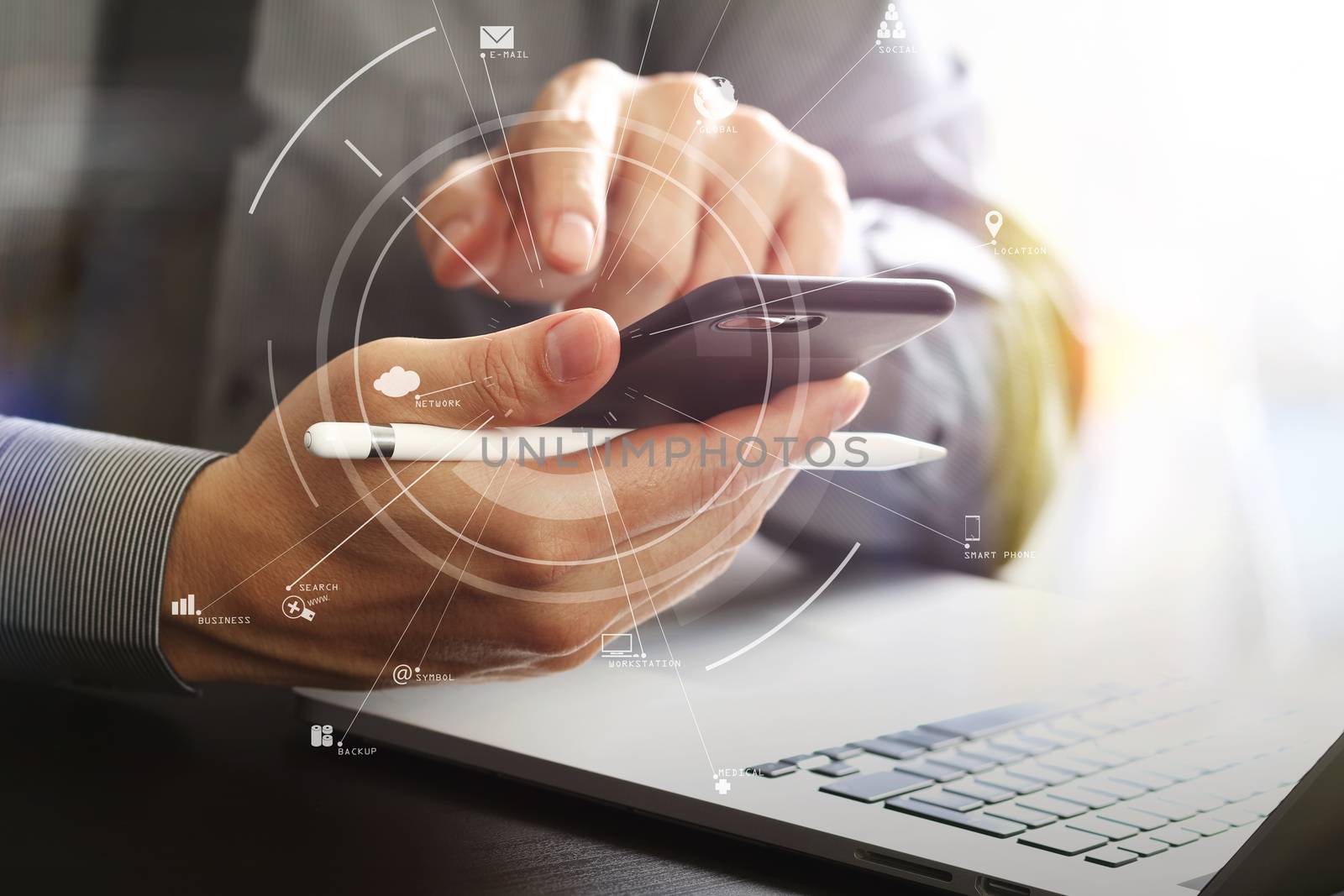 close up of businessman working with mobile phone and stylus pen and laptop computer on wooden desk in modern office with virtual icon diagram