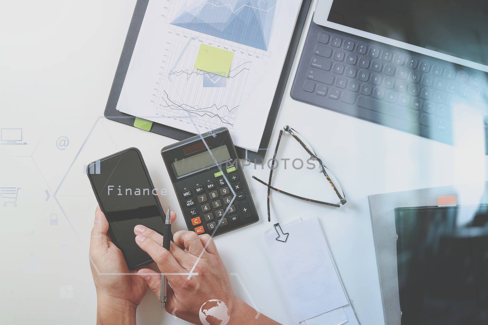 top view of businessman hand working with finances about cost and calculator and latop with mobile phone on withe desk in modern office with VR icon diagram