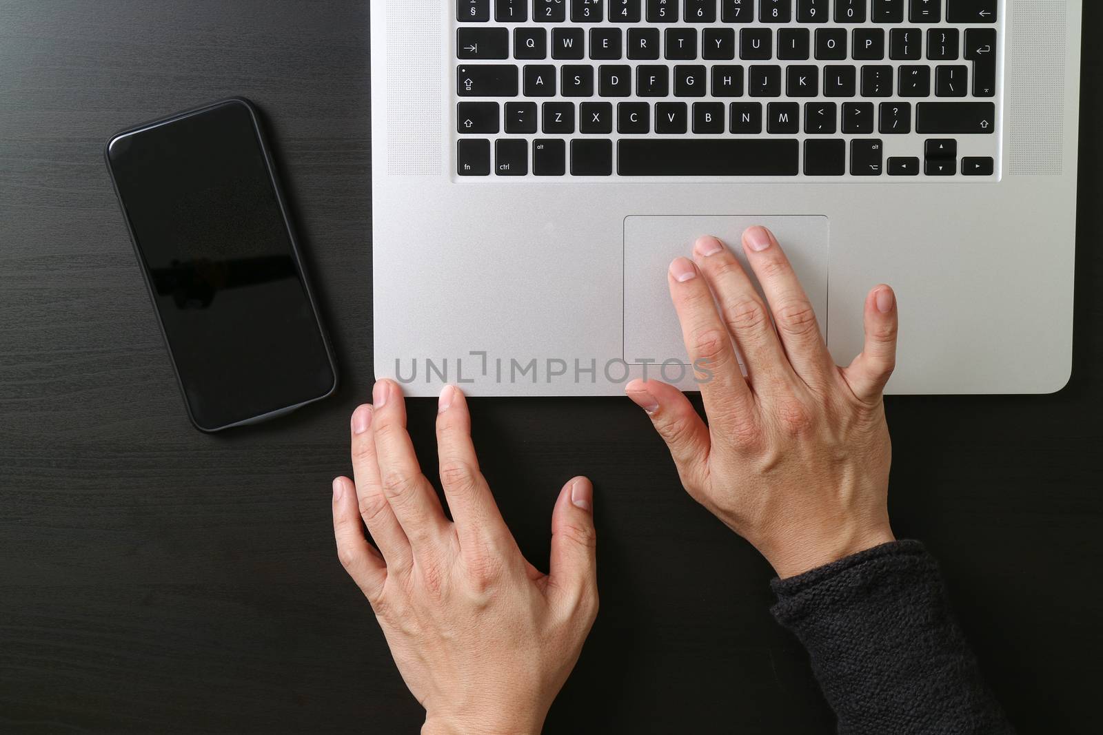 cyber security internet and networking concept.Businessman hand working mobile phone on laptop computer background