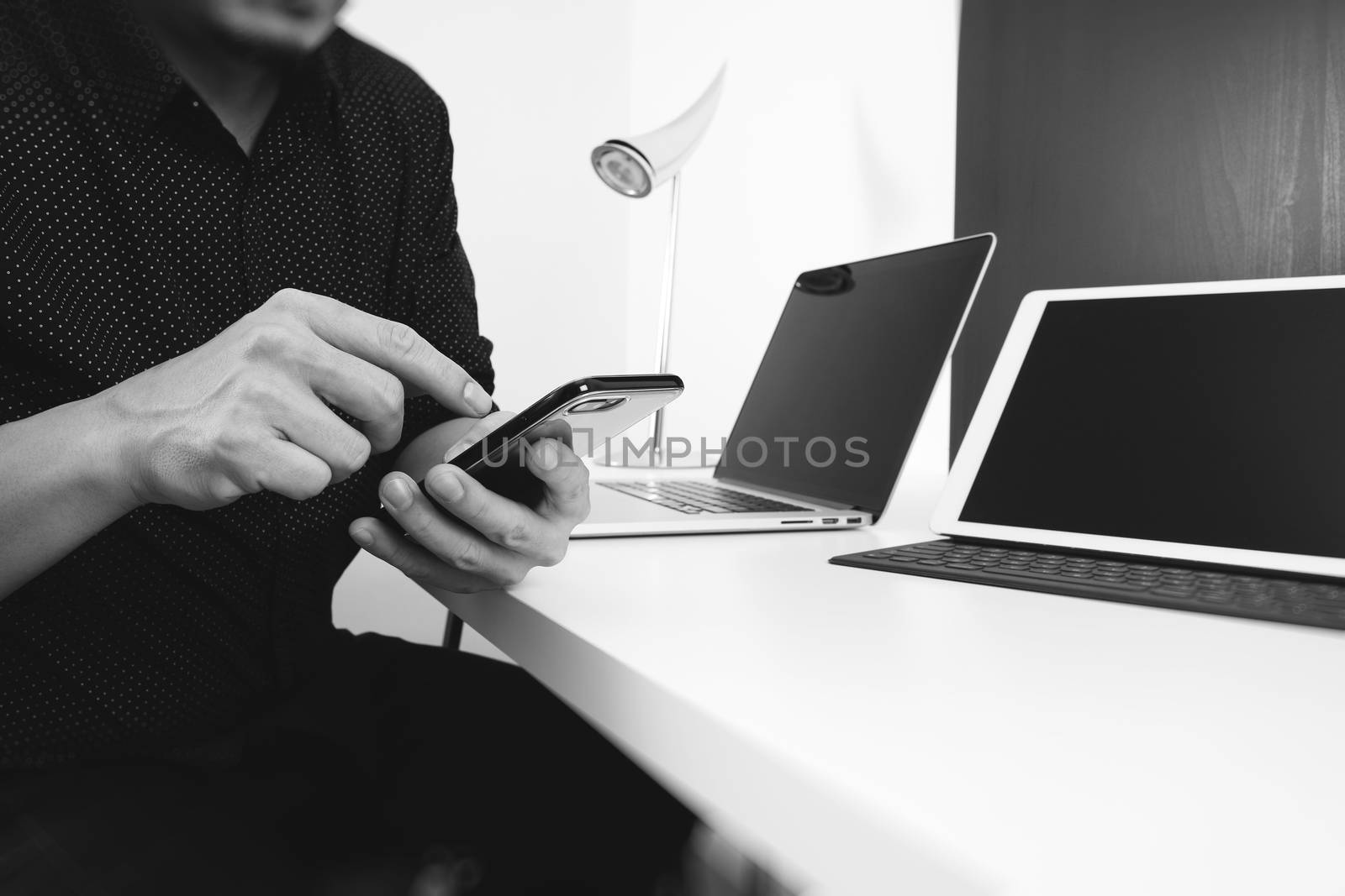 businessman working with smart phone and digital tablet and laptop computer in modern office ,black and white