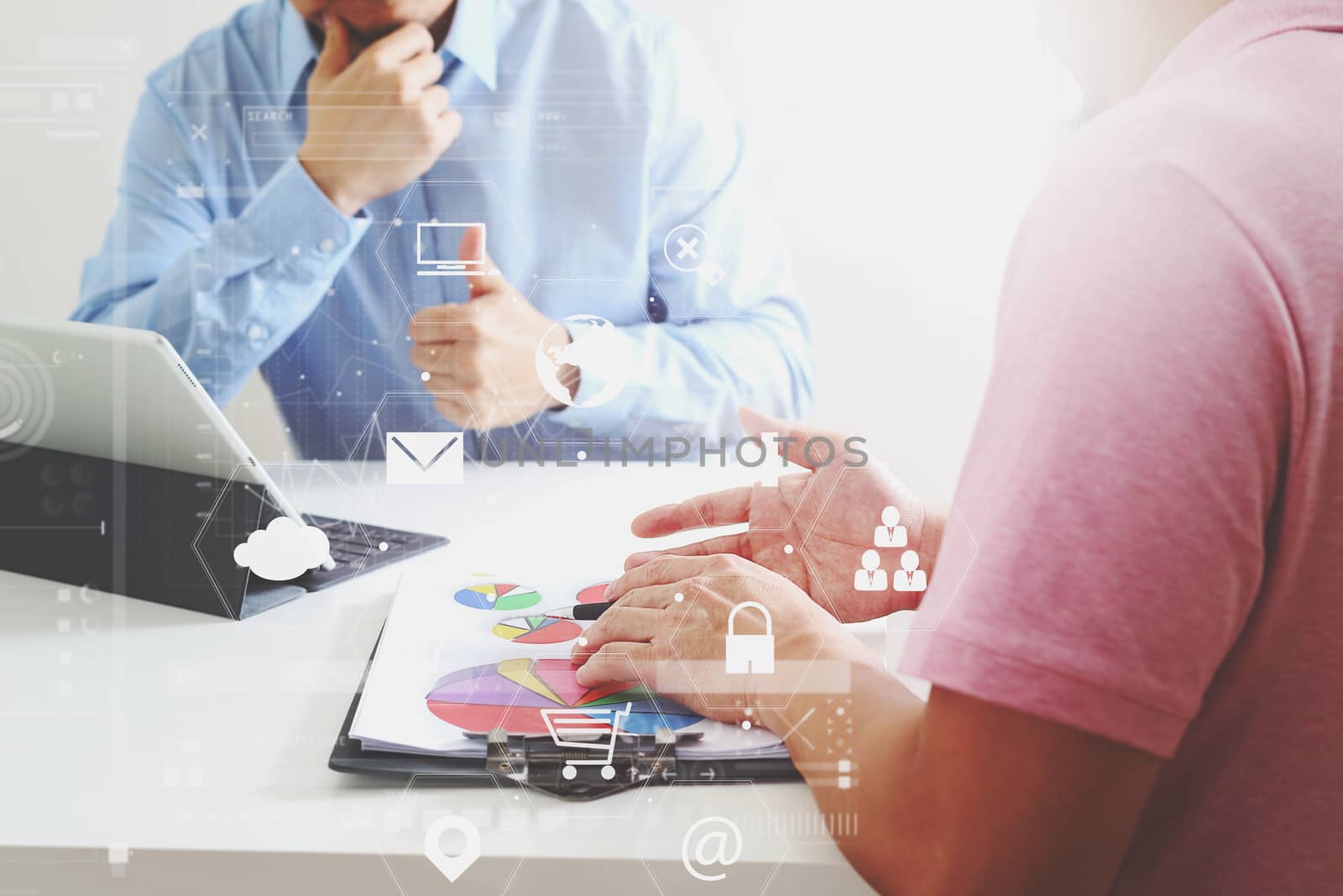 Businessmen working together on a document and using smart phone and digital tablet and laptop computer in modern office with VR icon diagram                                                              