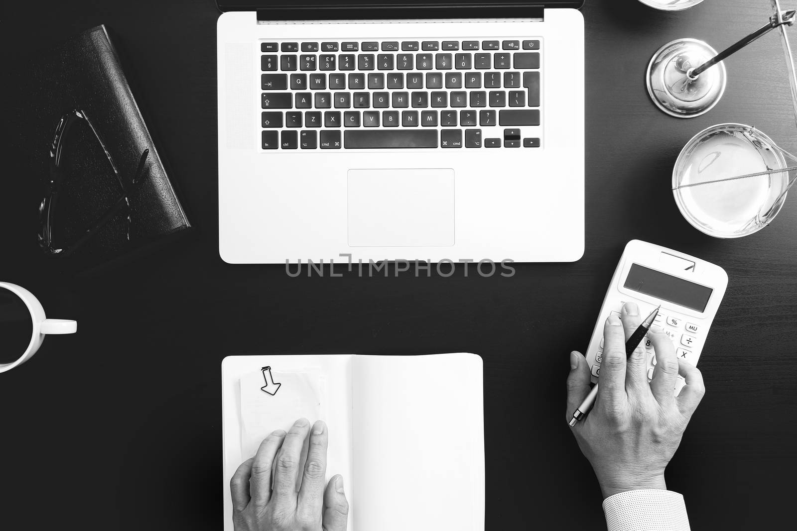 justice and law concept.businessman or lawyer or accountant working on accounts using a calculator and laptop computer and documents in modern office,black and white