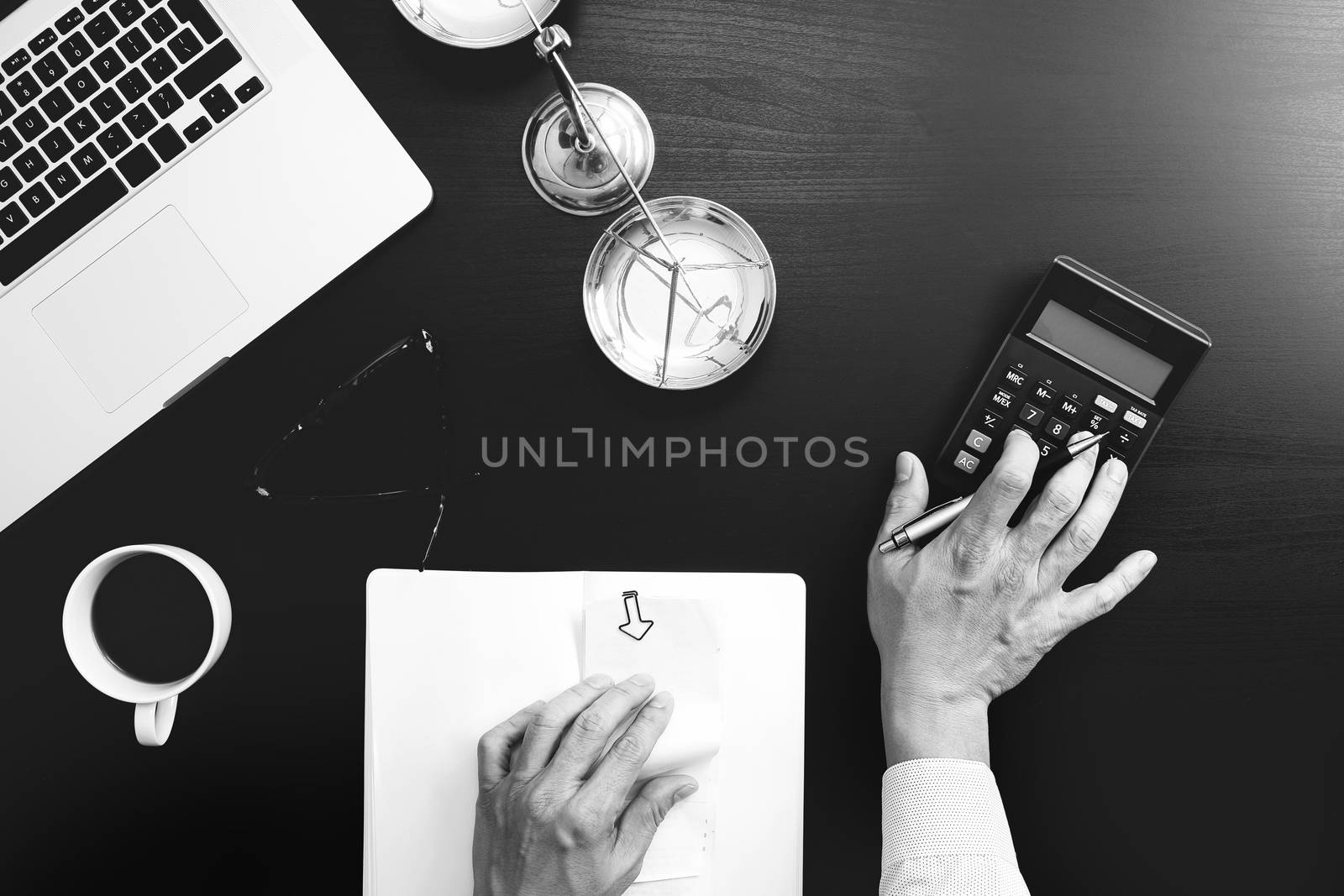 justice and law concept.businessman or lawyer or accountant working on accounts using a calculator and laptop computer and documents in modern office,black and white