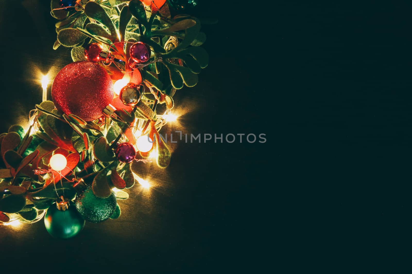 Greeting Season concept.Christmas wreath with decorative light on dark wood background