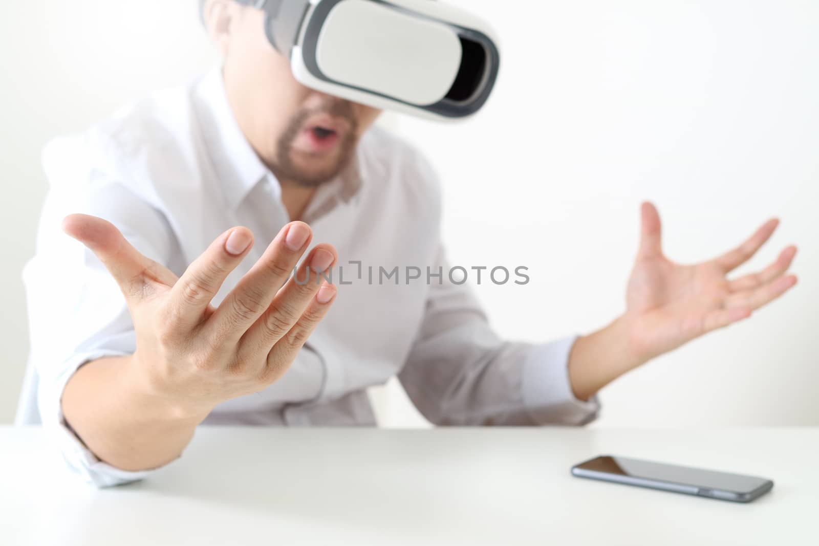 businessman wearing virtual reality goggles in modern office with mobile phone using with VR headset 