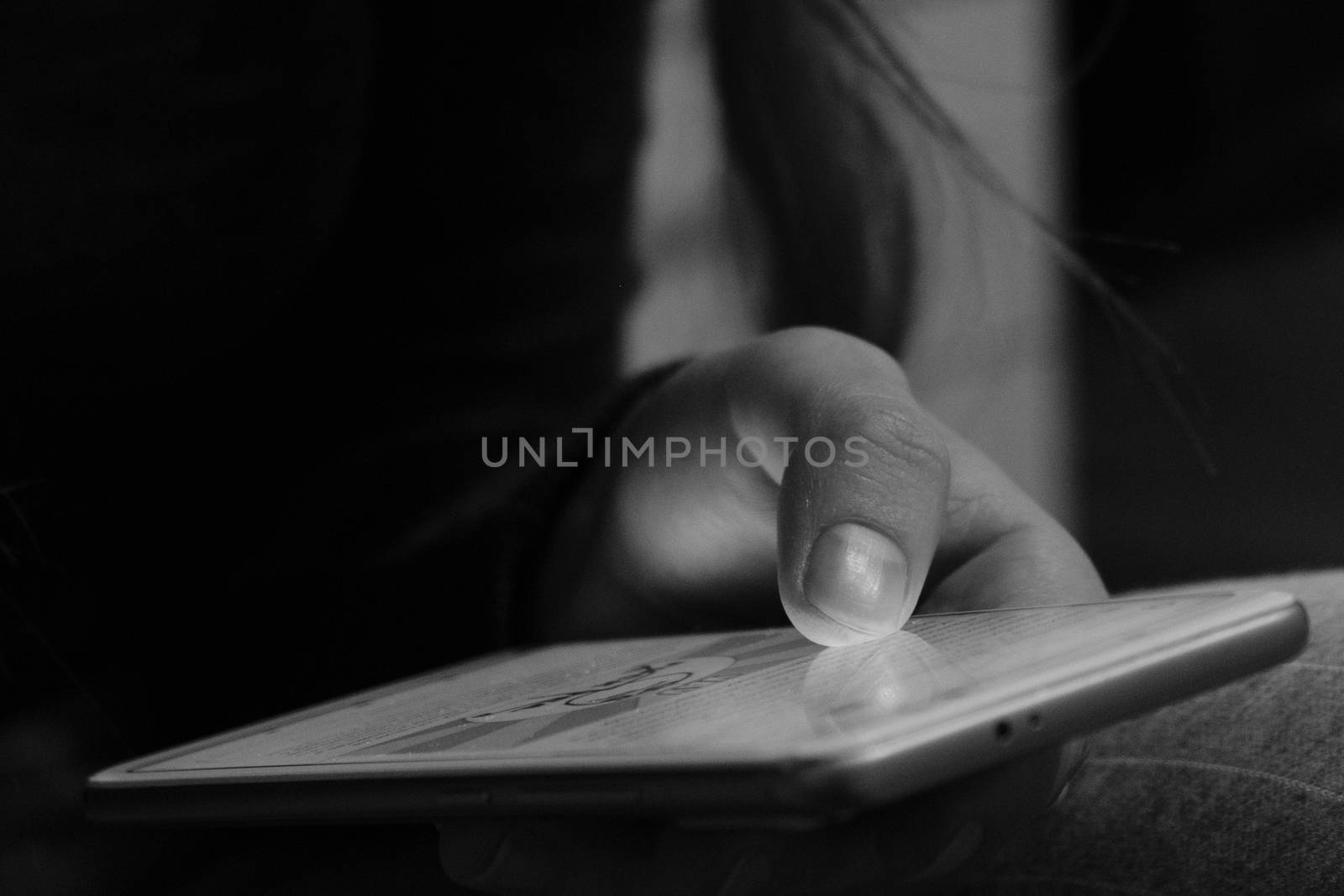 A woman uses a smart phone. Hands and phone close-up. Black and white image