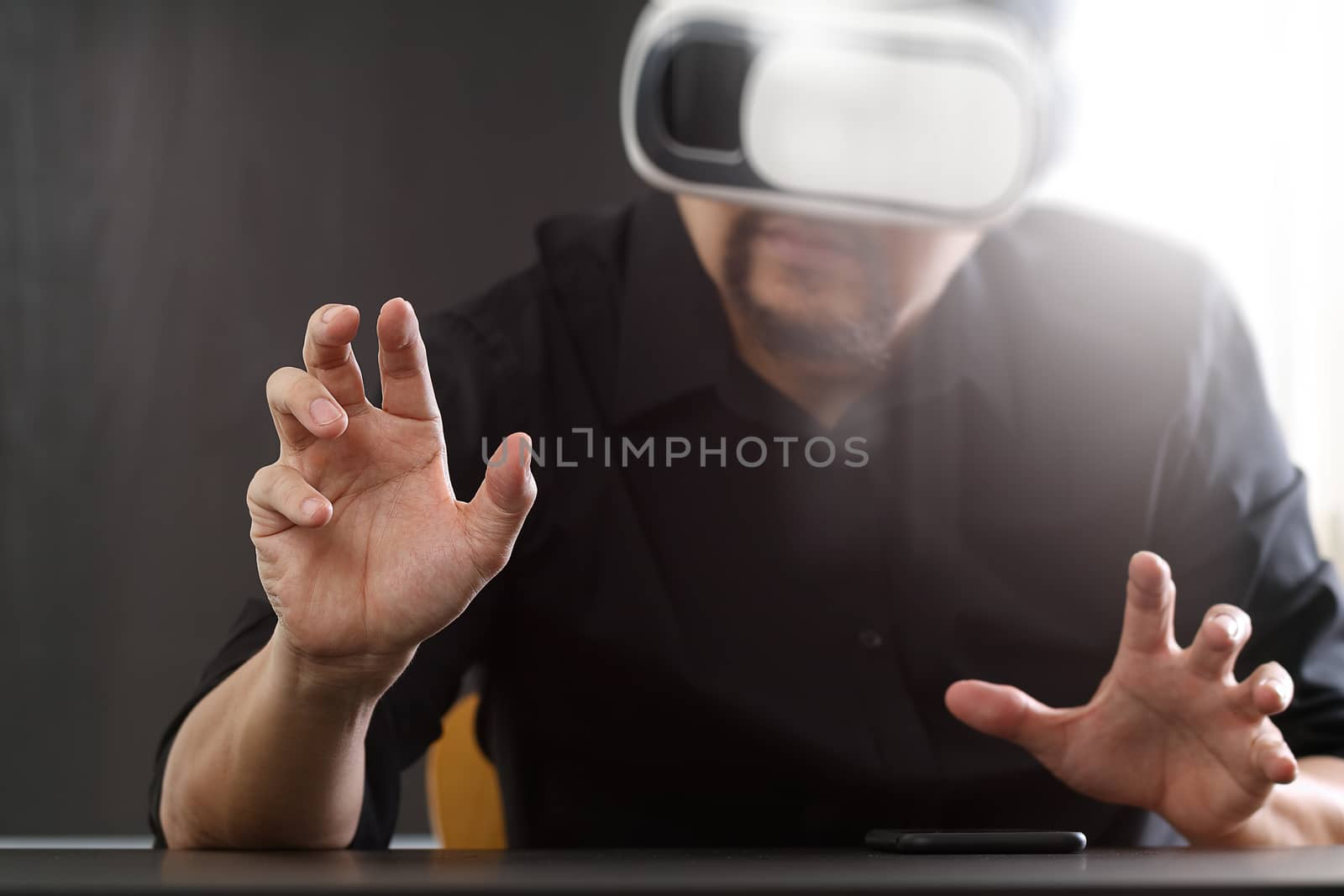 businessman wearing virtual reality goggles in modern office wit by everythingpossible