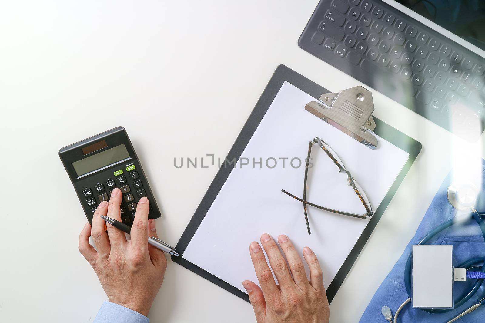 top view of Healthcare costs and fees concept.Hand of smart doctor used a calculator for medical costs in modern hospital 