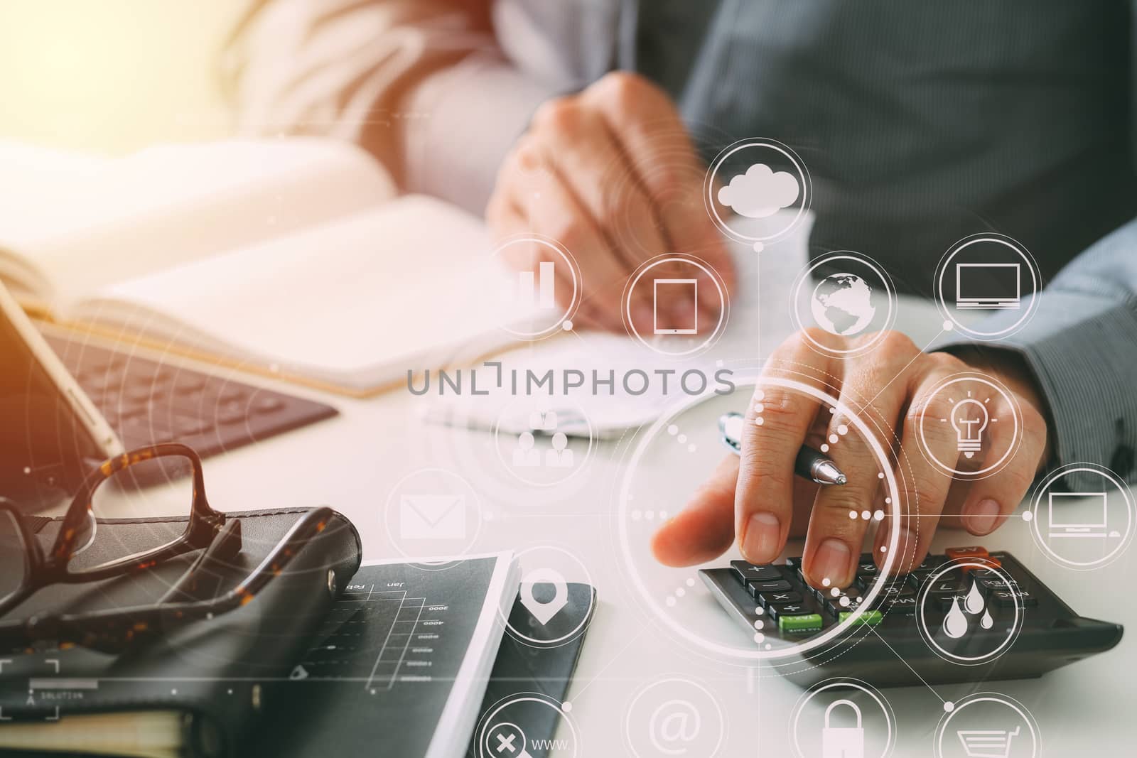 businessman hand working with finances about cost and calculator and latop with mobile phone on withe desk in modern office with VR icon diagram