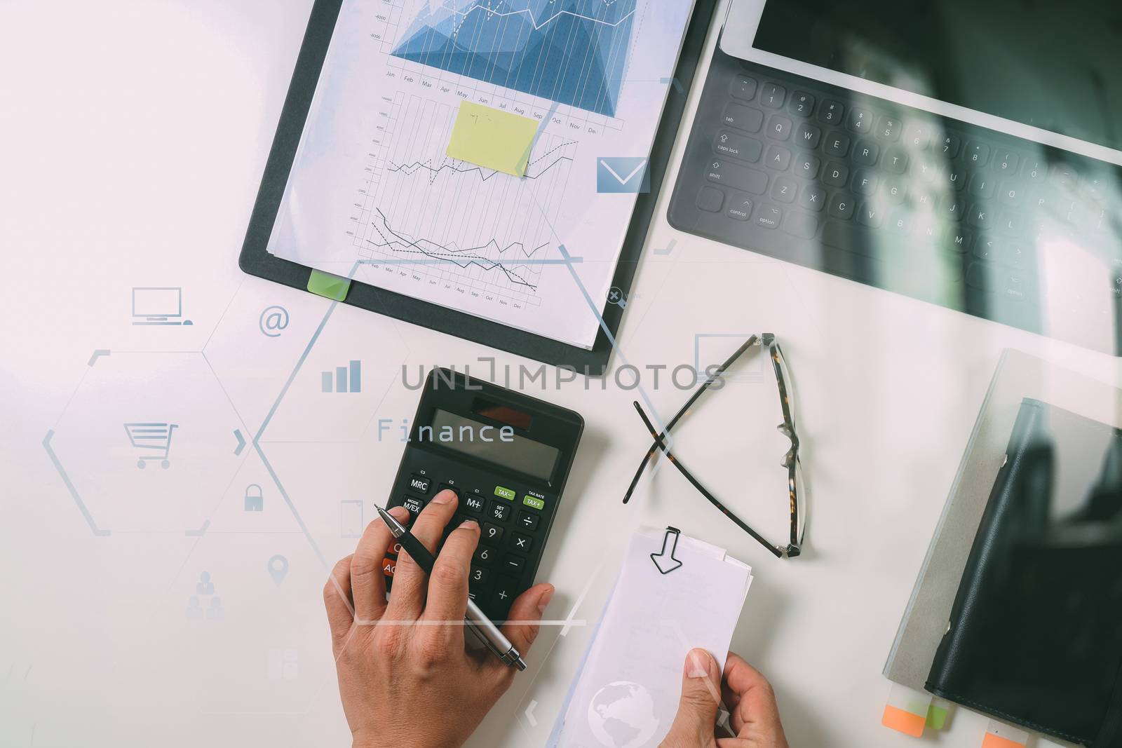 top view of businessman hand working with finances about cost and calculator and latop with mobile phone on withe desk in modern office with VR icon diagram