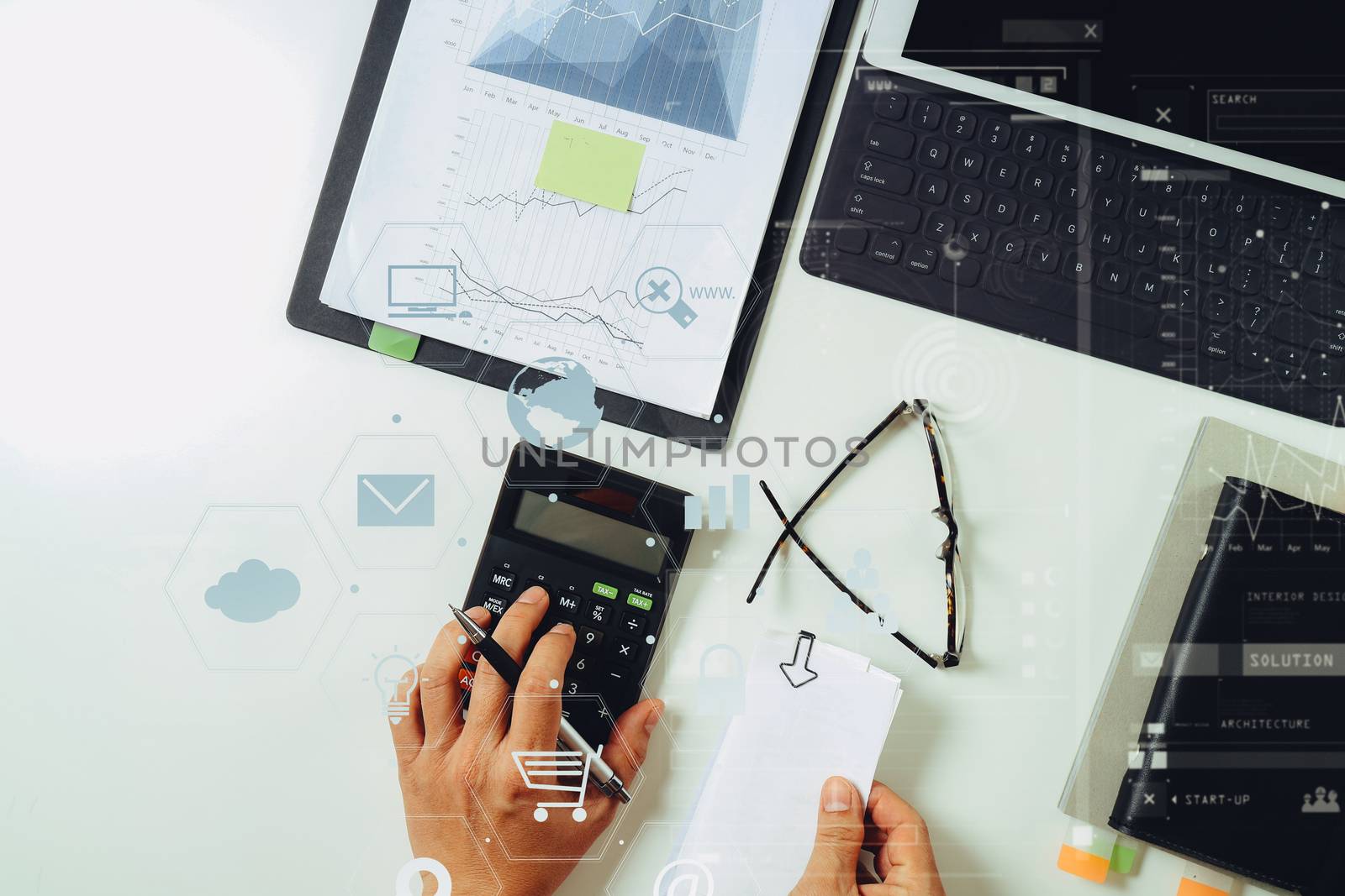 top view of businessman hand working with finances about cost and calculator and latop with mobile phone on withe desk in modern office with VR icon diagram