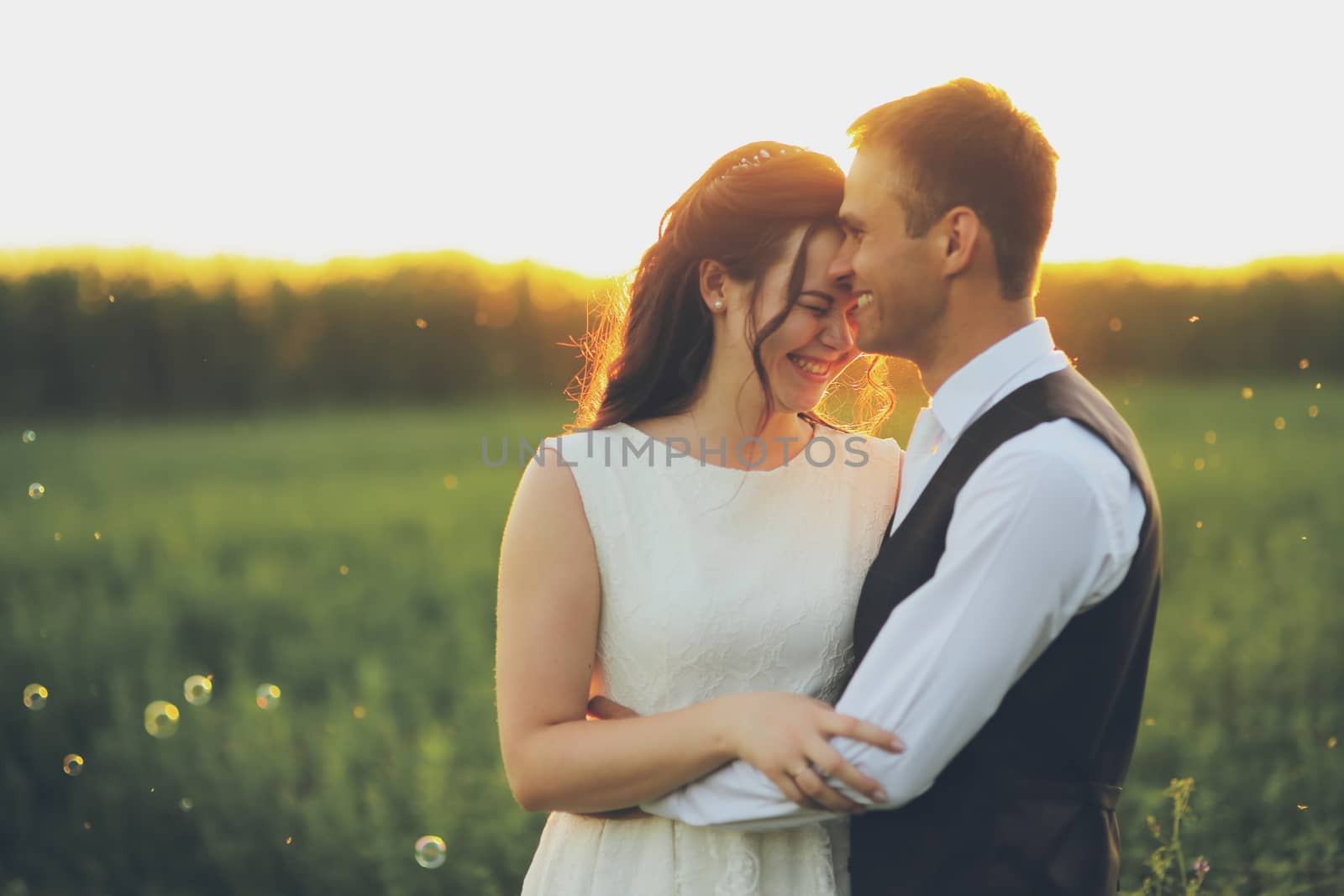 Happy bride and groom hug each other in the park at sunset. Wedding. Happy love concept. High quality photo