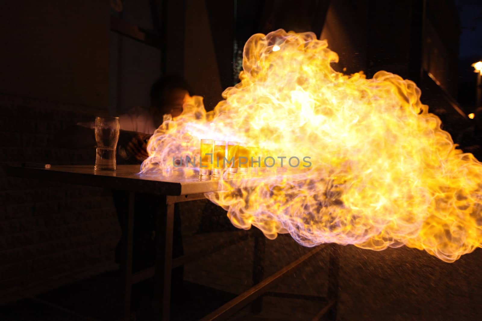 Bartender throwing flame on alcoholic drinks