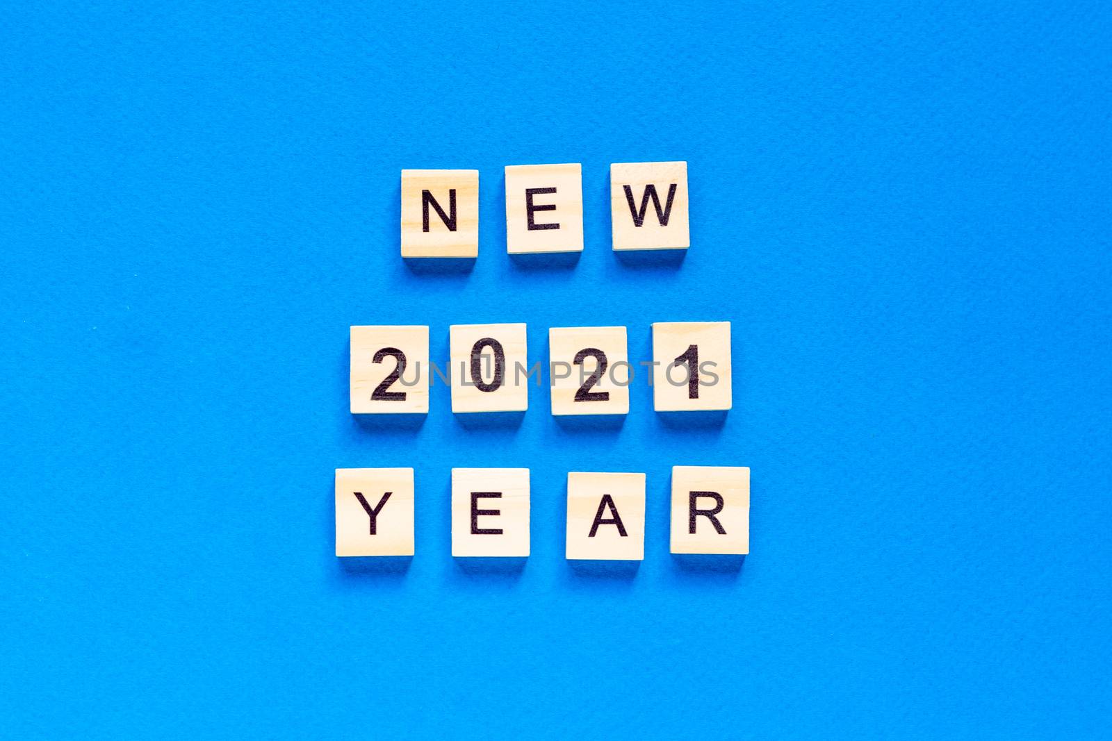 Happy New year written in wooden letters on a blue background. Happy new year 2021. top view. flat layout. space for text.