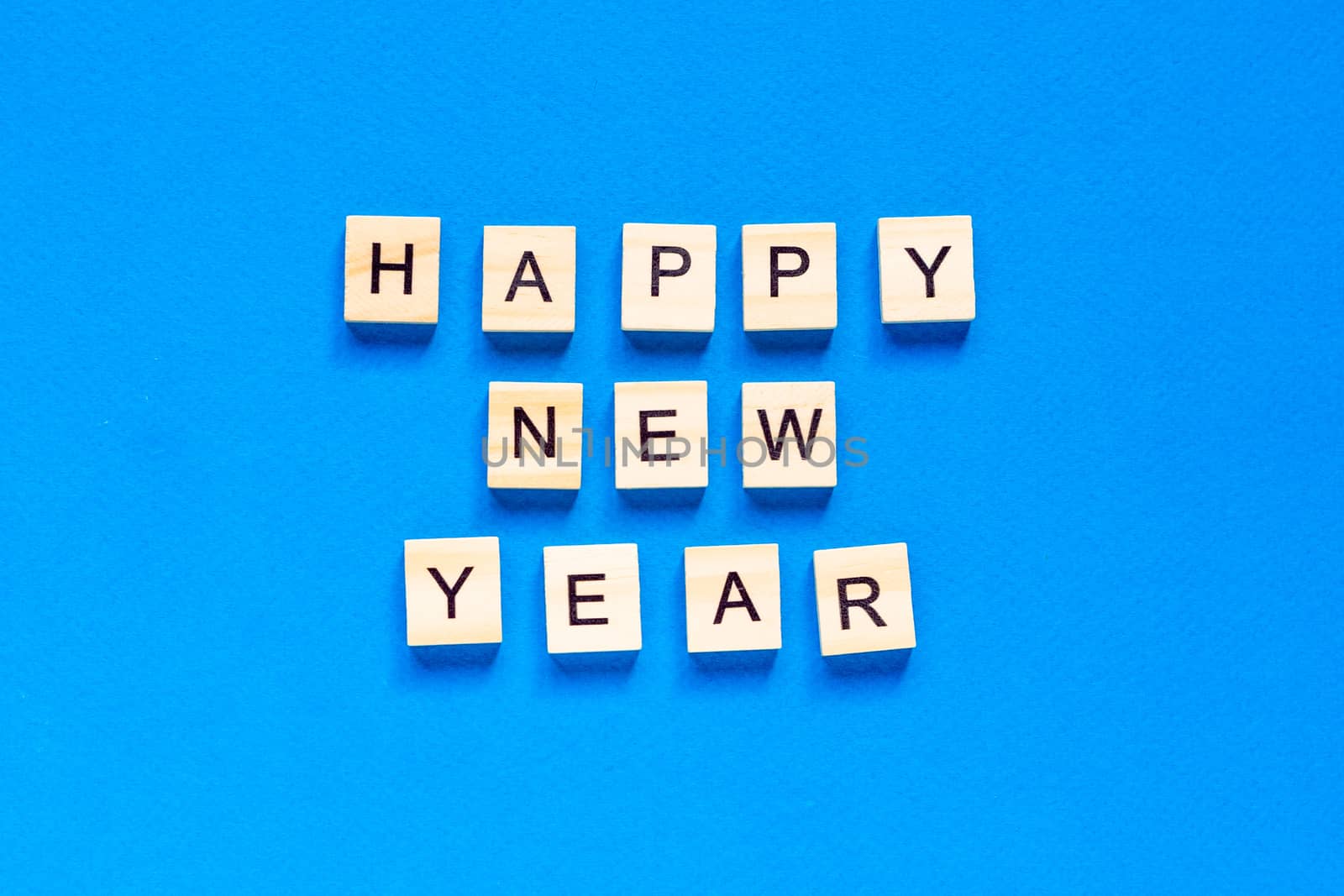 Happy New year written in wooden letters on a blue background. Happy new year 2021. top view. flat layout. space for text.