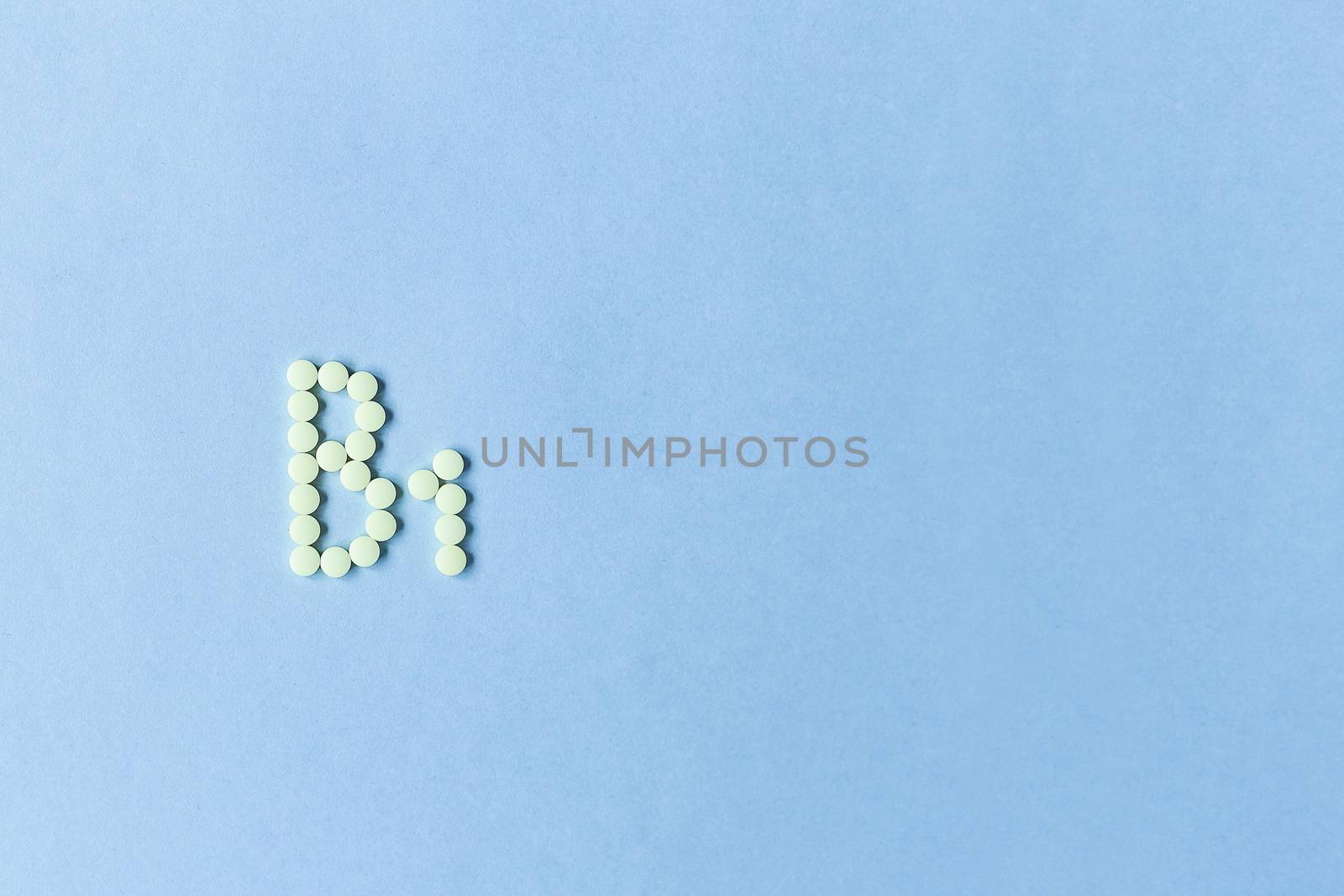 Yellow tablets forming B1 on a blue background. Vitamin complex. Concept, health care, healthy nutrition. Medicine. Healthy lifestyle. Good. Food additive. copy space. Soft focus. blurry background