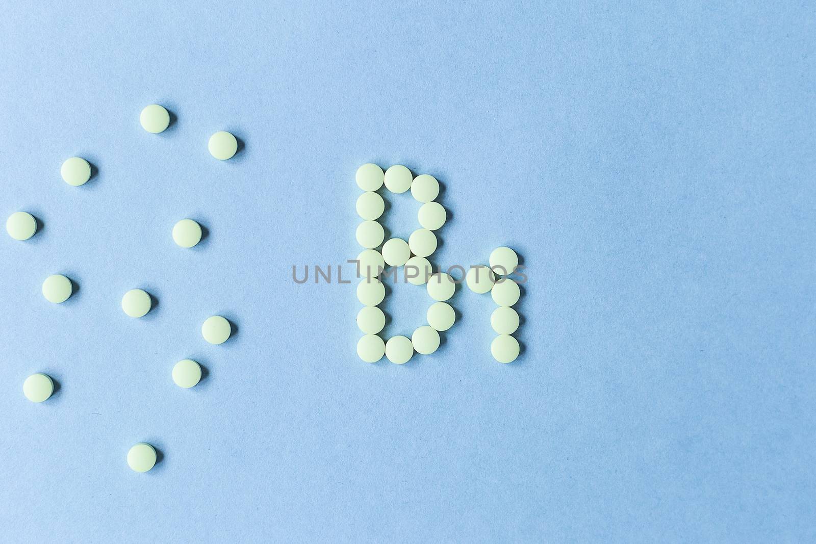 Yellow tablets forming B1 on a blue background. Vitamin complex. Concept, health care, healthy nutrition. Medicine. Healthy lifestyle. Food additive. copy space. Soft focus. blurry background. Good by Pirlik