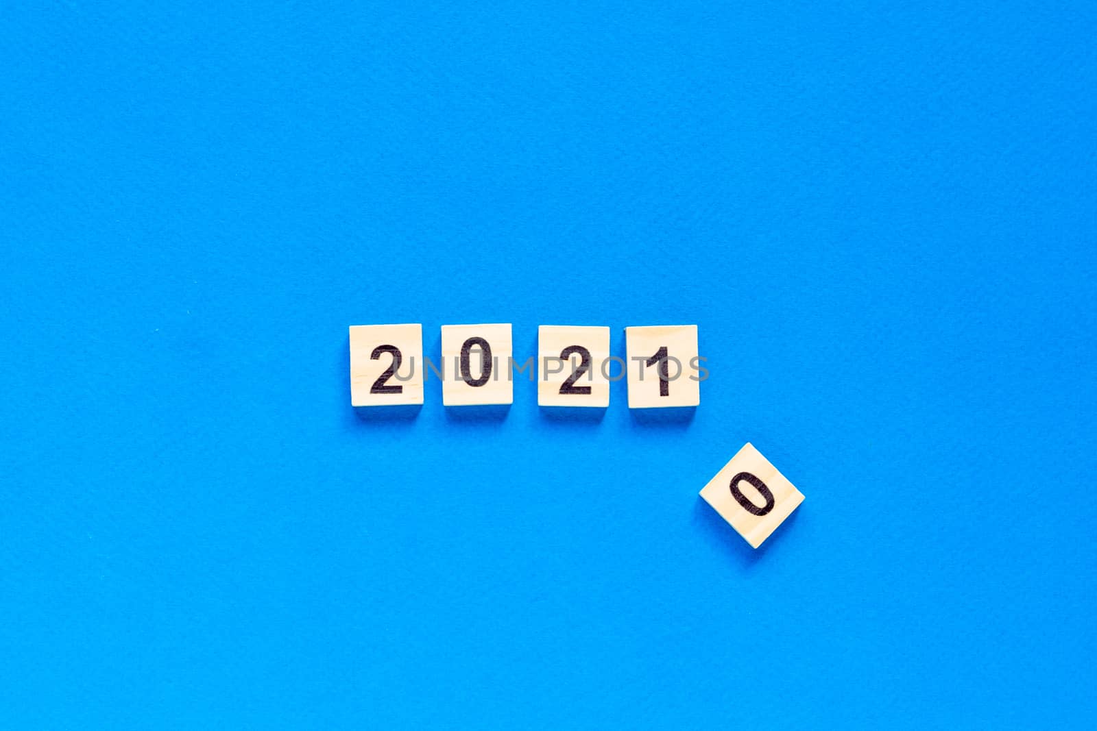 Happy New year written in wooden letters on a blue background. Happy new year 2021. top view. flat layout. space for text.