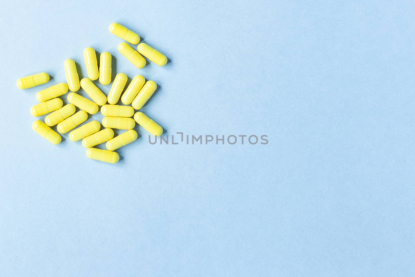 Yellow capsules on a blue background. Omega-3 vitamins. food Supplement. Fish oil in capsules. Free space. space for text. copy space. blurred background. Selective focus. banner. concept of medicine.