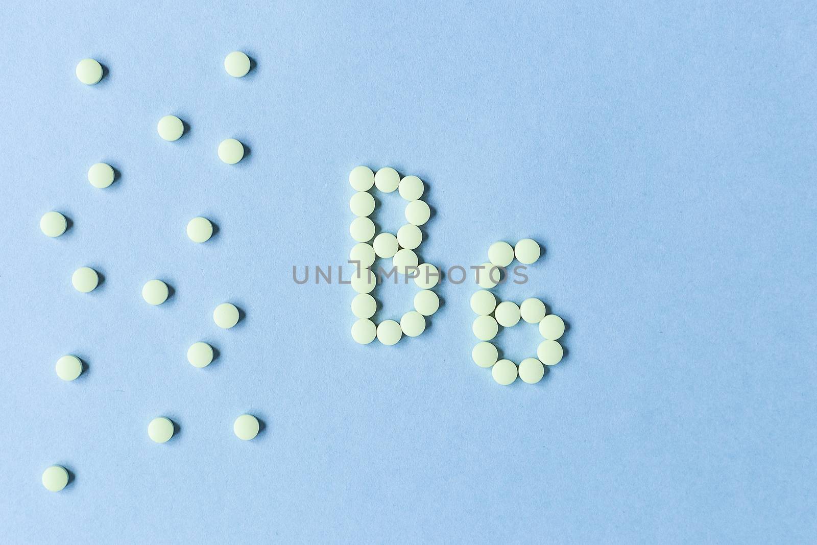 Vitamin B6 pills forming the word B6 over turquoise background, banner. free space. space for text. copy space. soft focus, blurry background. nutritional supplements, healthy food, health maintenance by Pirlik