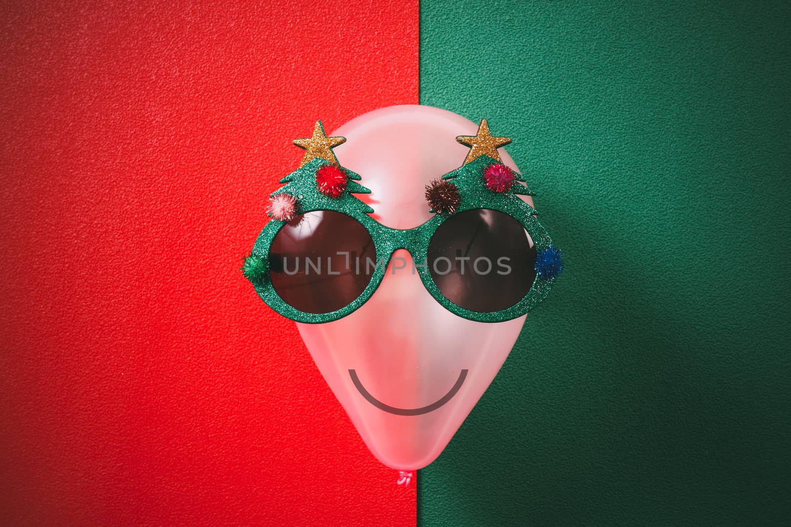 Christmas glasses that decoration with Christmas tree on air bolloon on green background