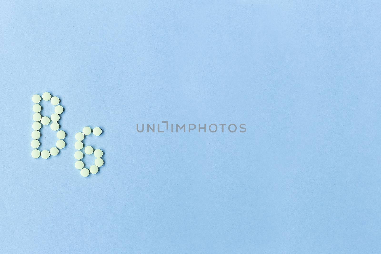 Vitamin B6 pills forming the word B6 over turquoise background, banner. free space. copy space. soft focus, blurry background. space for text. nutritional supplements, healthy food, health maintenance