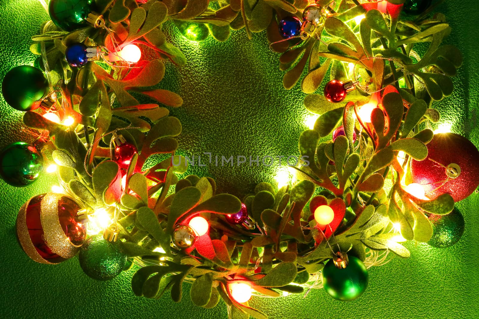 Greeting Season concept.Christmas wreath with decorative light on green background