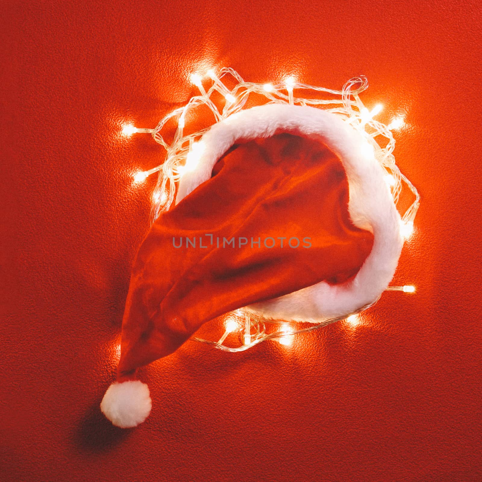Greeting Season concept.Santa Claus hat with christmas light on red and green background