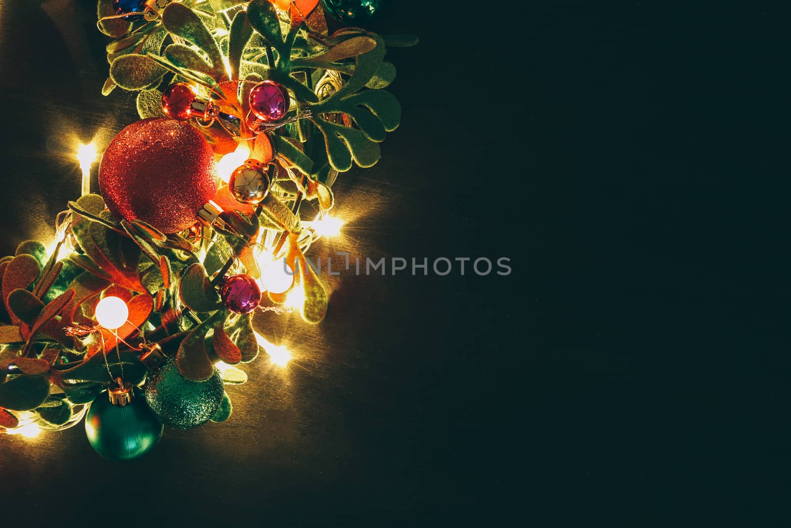 Greeting Season concept.Christmas wreath with decorative light on dark wood background