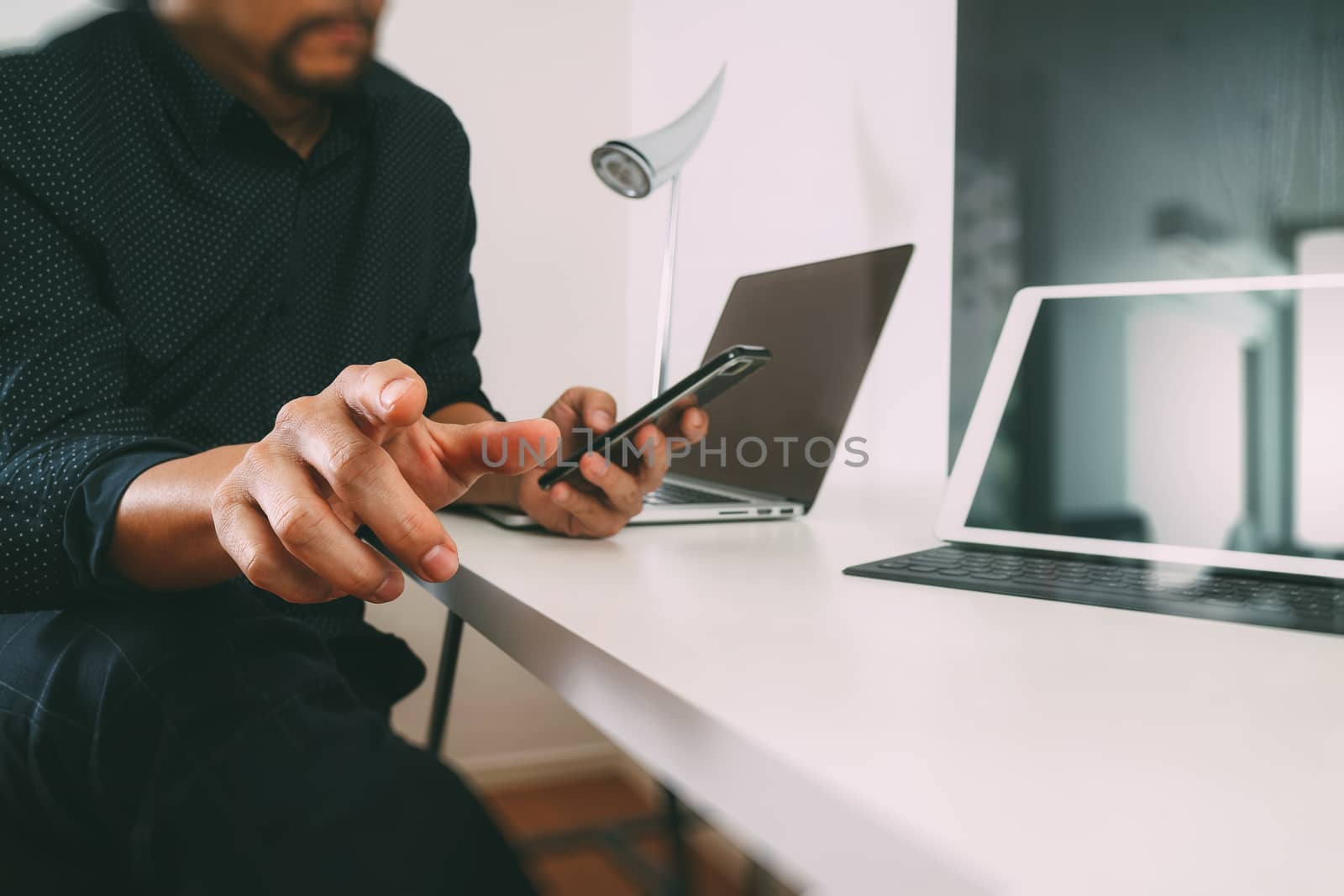 businessman working with smart phone and digital tablet and laptop computer in modern office