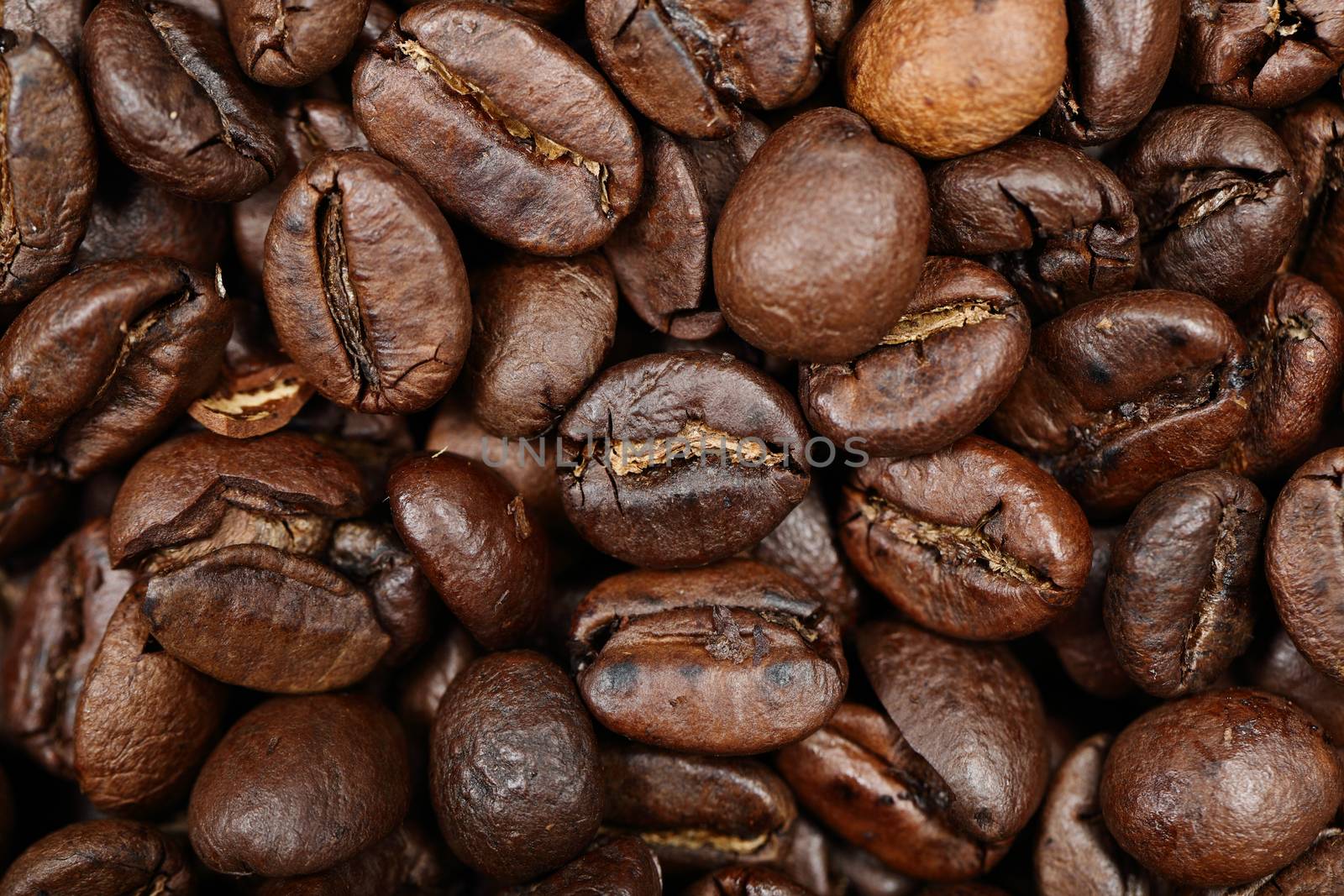 Coffee beans texture background closeup. Dark roast arabica coffee bean closeup.
