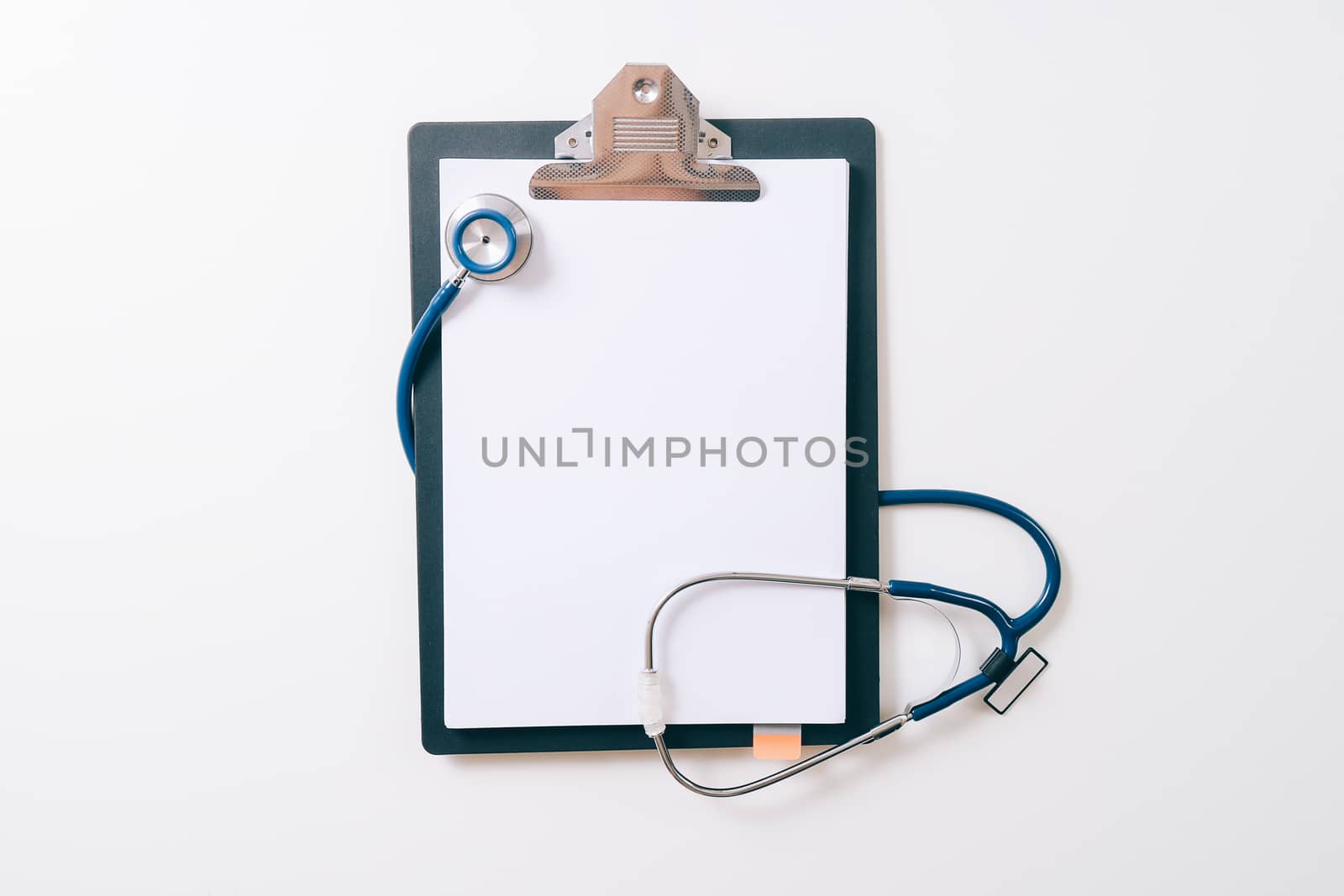 blank stethoscope and gray clipboard on white desk background