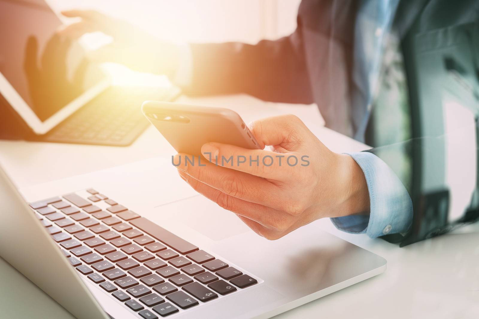 Hands of businessman using mobile phone in modern office with la by everythingpossible
