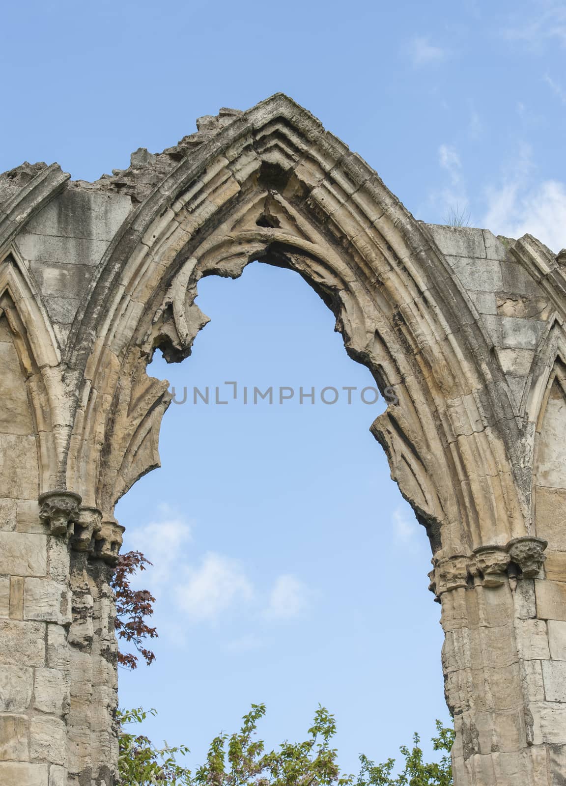 Ancient medieval church ruins against blue sky in english city center