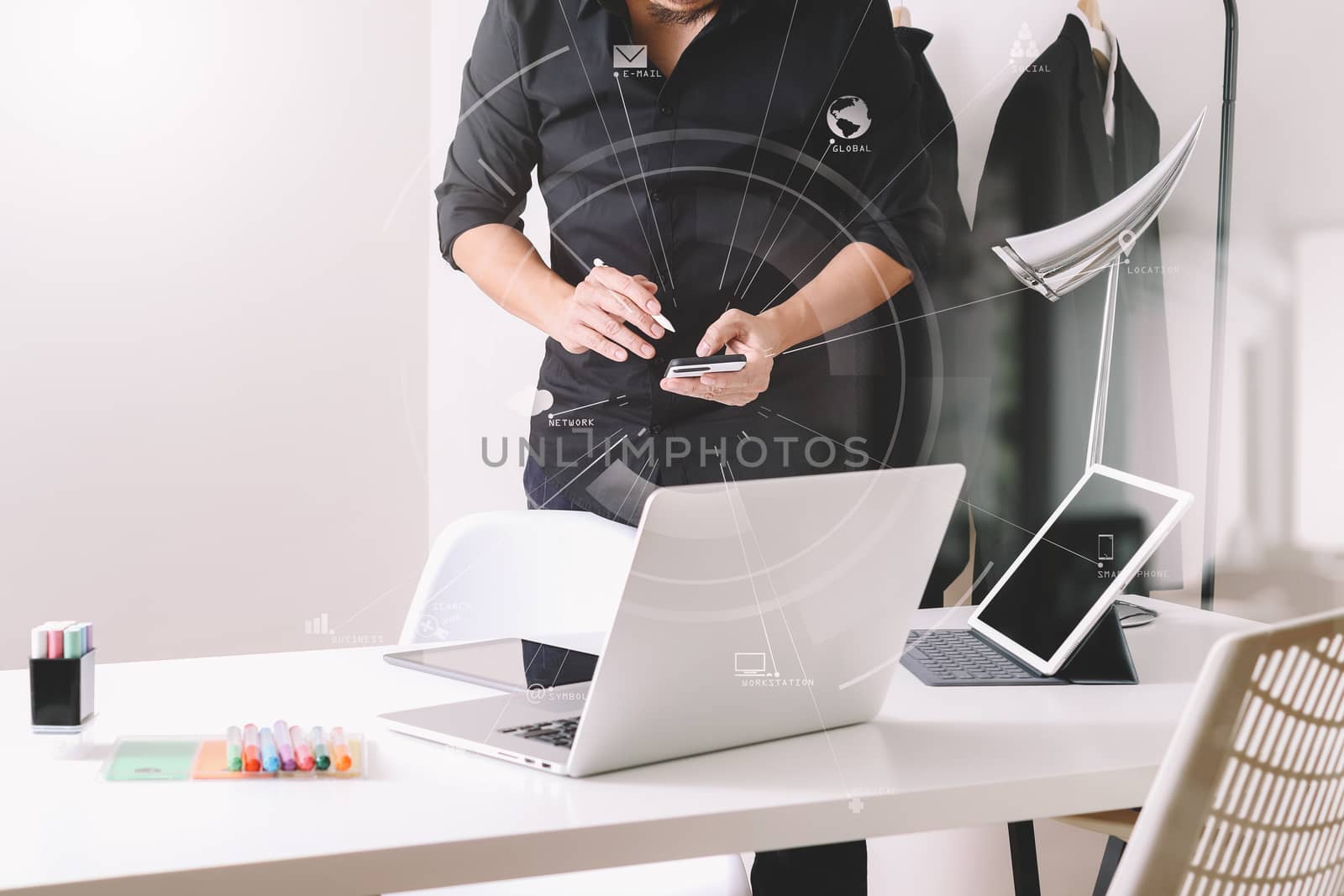 Fashion designer working with mobile phone and using laptop with by everythingpossible