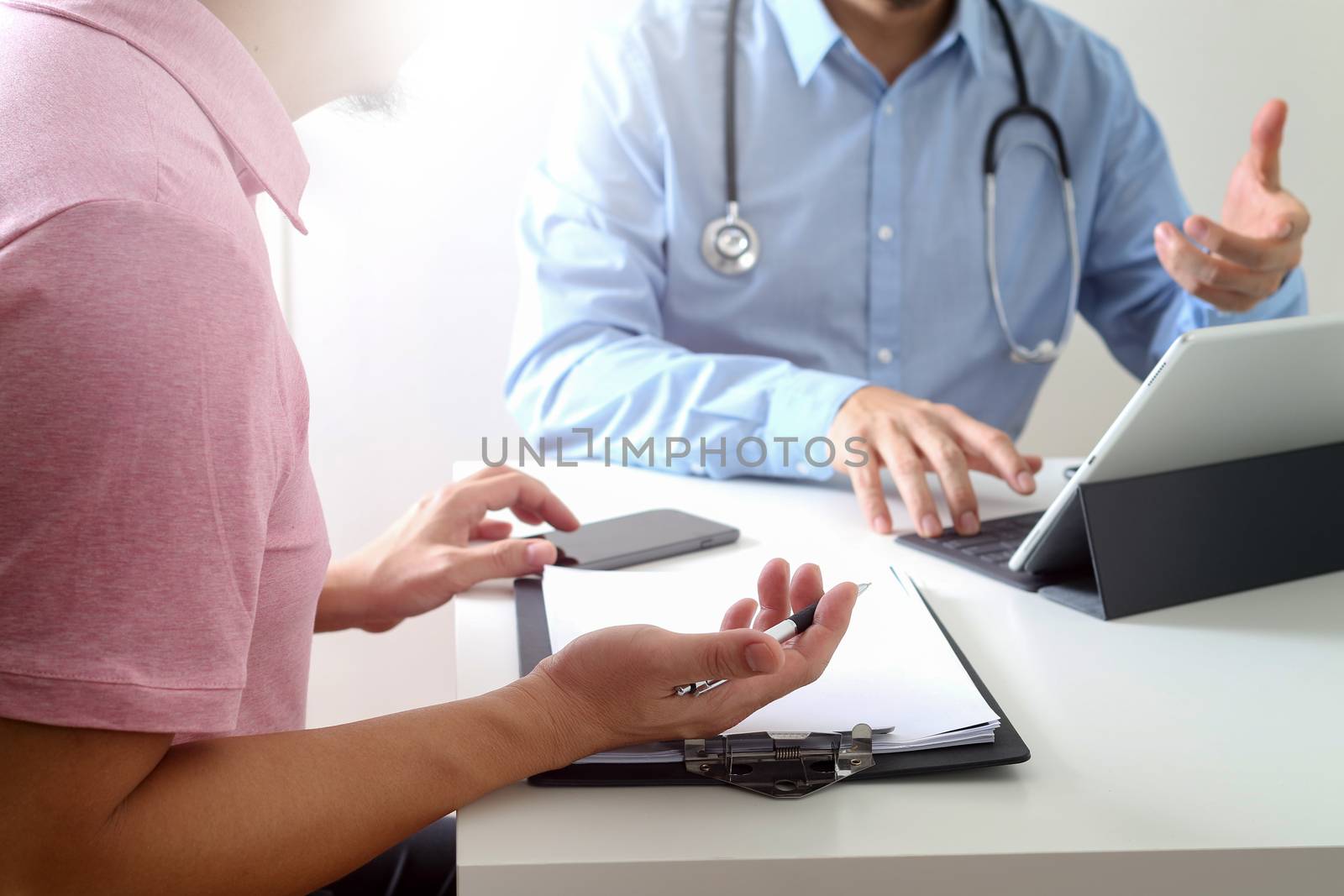 Medical doctor using mobile phone and consulting businessman patient having exam as Hospital professionalism concept 