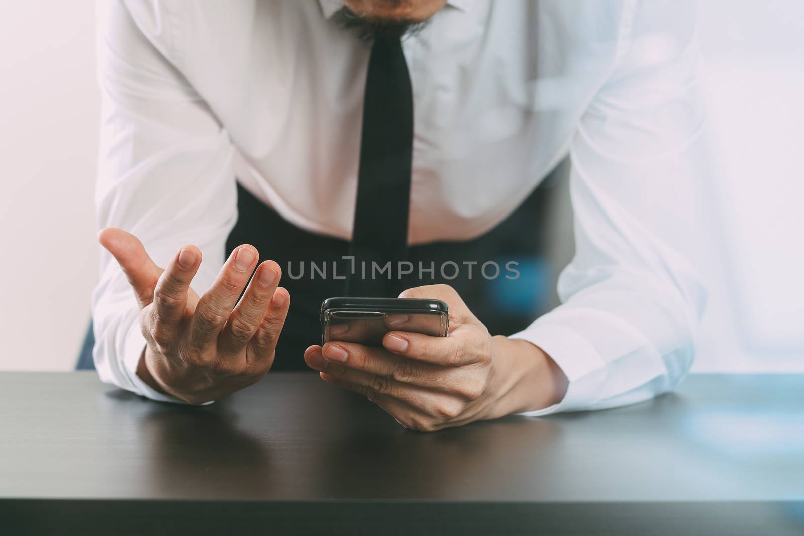 close up of businessman working with smart phone on wooden desk  by everythingpossible