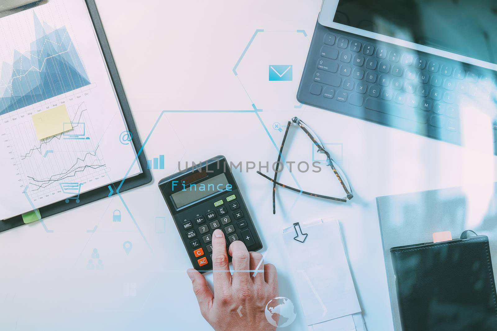 top view of businessman hand working with finances about cost and calculator and latop with mobile phone on withe desk in modern office with VR icon diagram
